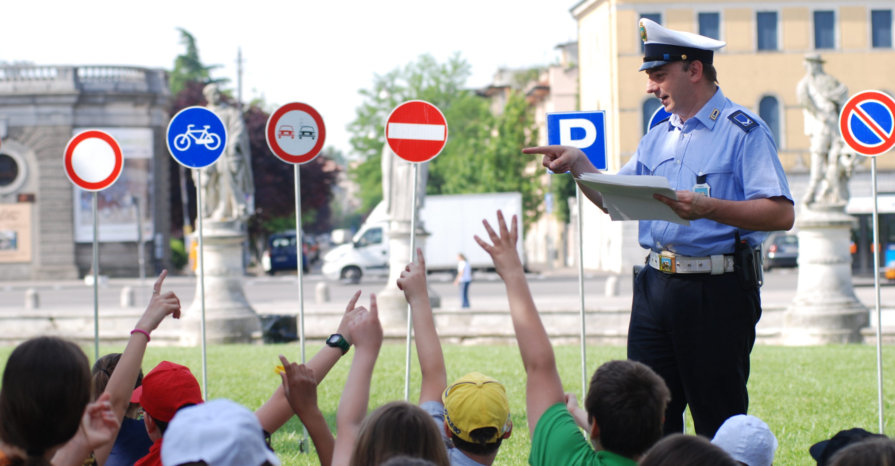Agente di Polizia locale che insegna i cartelli ai bambini